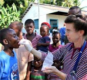 An aid worker gives medicine to Haitian child in Léogâne