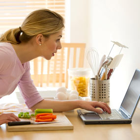 Woman on laptop in the kitchen.